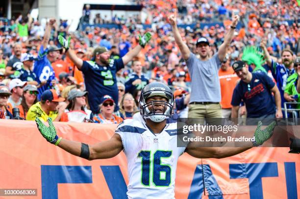 Wide receiver Tyler Lockett of the Seattle Seahawks celebrates after scoring a fourth quarter touchdown under coverage by defensive back Justin...