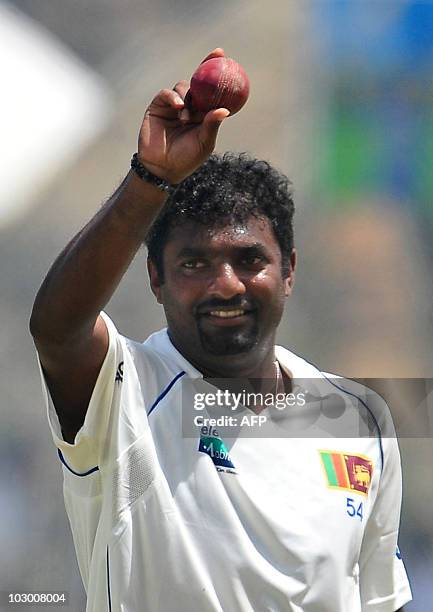 Sri Lankan cricketer Muttiah Muralitharan waves at the end of the Indian team's first innings during the fourth day of the first Test match between...