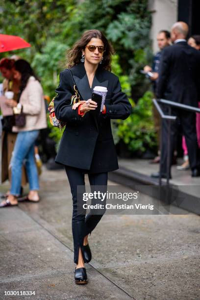Leandra Medine wearing cardigan, blazer, black pants with slit is seen outside Brock Collection during New York Fashion Week Spring/Summer 2019 on...