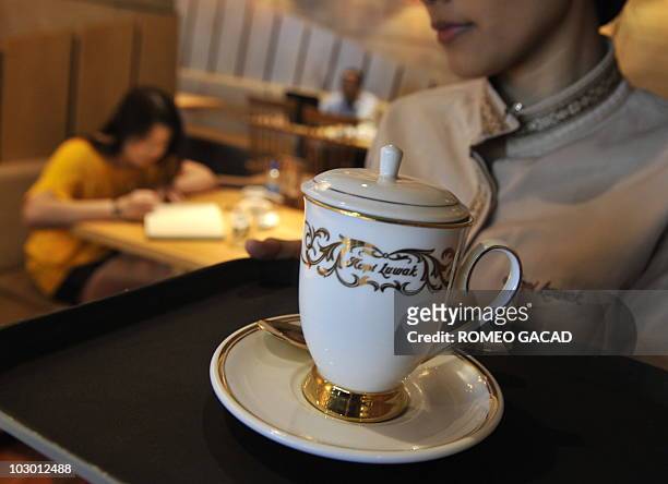 An employee serves an 80,000 rupiah cup of Kopi Luwak at a local coffee shop in Jakarta on July 20, 2010 serving the world's priciest and rarest...