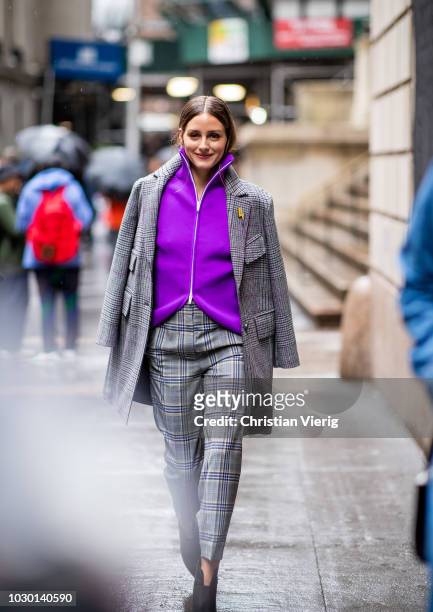 Olivia Palermo wearing purple zipped jacket, grey plaid wool coat and pants, ankle boots is seen outside Tibi during New York Fashion Week...