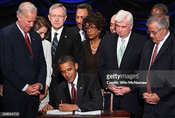 President Barack Obama signs the Dodd-Frank Wall Street Reform and Consumer Protection Act before Vice President Joe Biden, Speaker of the House...