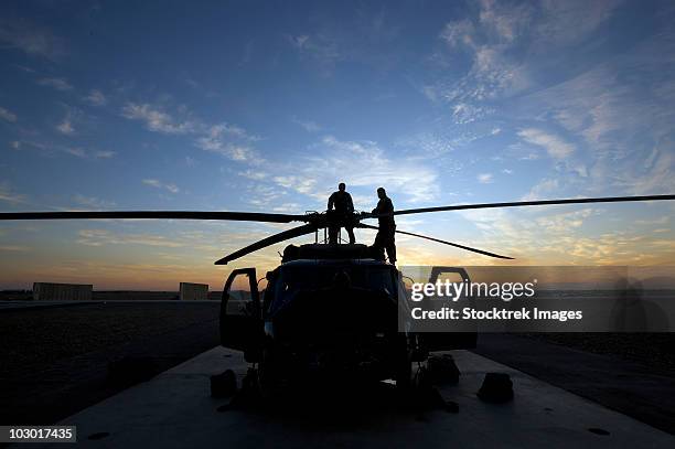 tikrit, iraq - a uh-60 black hawk helicopter on the flight line at sunset. - iraq tikrit stock pictures, royalty-free photos & images