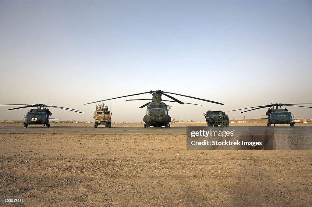 U.S. military vehicles and aircraft lined up on the taxiway at Camp  Speicher, Iraq.