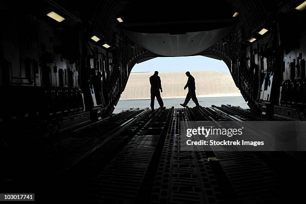 c-17a globemaster iii loadmasters go through prefight checks on the ramp. - frachtflugzeug stock-fotos und bilder