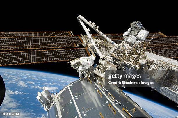 astronauts perform a series of tasks on the exterior of the international space station. - estação espacial internacional - fotografias e filmes do acervo