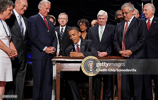 President Barack Obama signs the the financial reform bill into law during a ceremony with Robin Fox, Andrew Giordano, Vice President Joe Biden,...