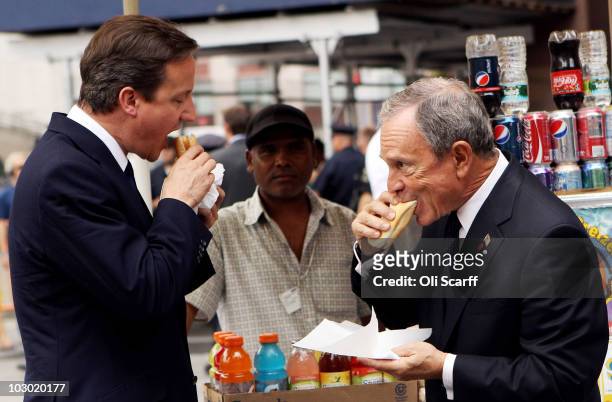 British Prime Minister David Cameron eats a hot dog with New York City Mayor Michael Bloomberg outside Penn Station on July 21, 2010 in New York...