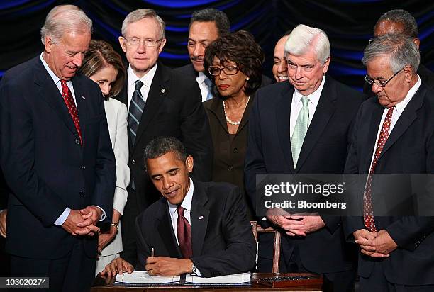 President Barack Obama signs the Dodd-Frank Wall Street Reform and Consumer Protection Act during a ceremony at the Ronald Reagan Building and...