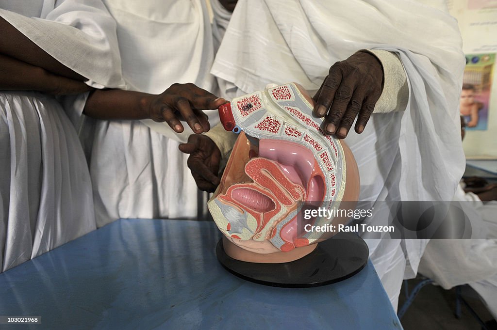 Midwife training using an anatomical model of a woman's pelvis.