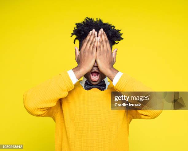 portrait nerdy young man covering eyes with hands - covering eyes stock pictures, royalty-free photos & images