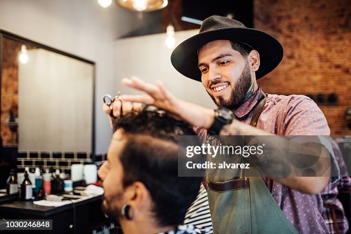 Sonriente de pelo de peluquería corte al cliente en el salón de Sonriente de pelo de peluquería corte al cliente en el salón de