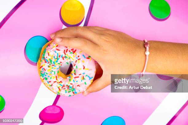 pink donuts with colorful toppings. - boulangerie industrielle photos et images de collection