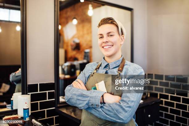 portret van vrouwelijke kapper glimlachend in kapsalon - barbers stockfoto's en -beelden