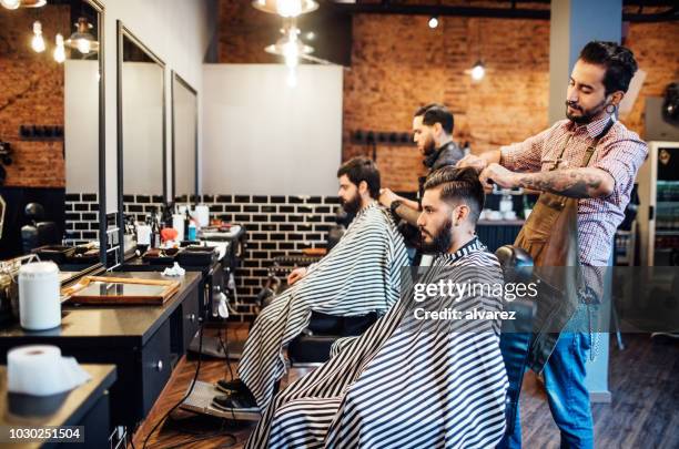 hairdressers cutting hair of clients in salon - man haircut stock pictures, royalty-free photos & images