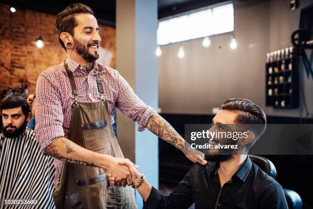 hairdresser shaking hands with customer in salon - barber shop 3 stock pictures, royalty-free photos & images