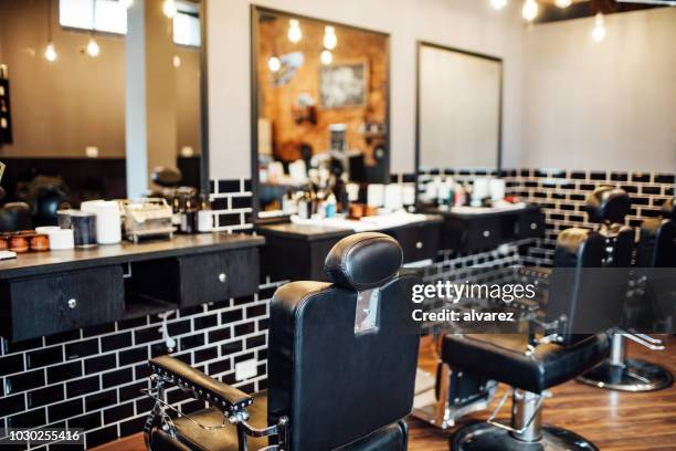 leere schwarze stühle und spiegel im friseurladen - salon stock-fotos und bilder