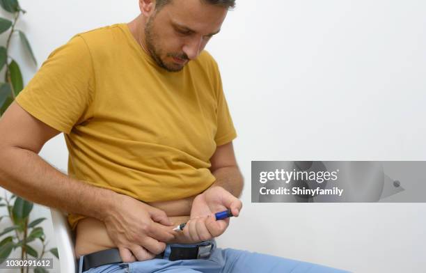 jovem injeta insulina na pele da barriga. - aplicando - fotografias e filmes do acervo