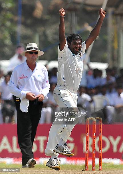 Sri Lankan cricketer Muttiah Muralitharan celebrates claming his 800th Test wicket with the dismissal of Indian cricketer Pragyan Ojha during the...