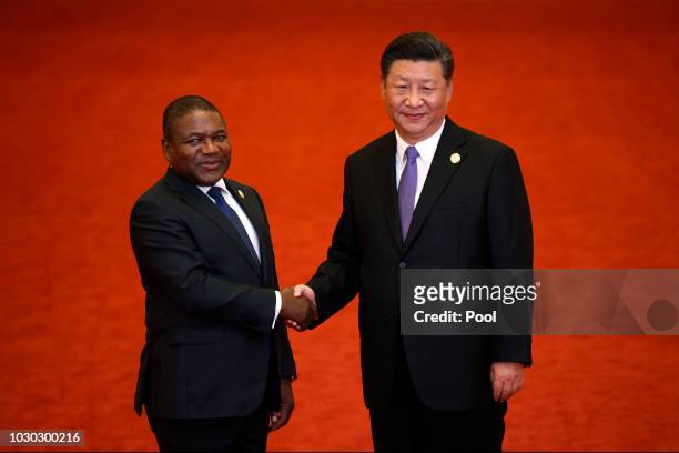 Mozambique's President Filipe Nyusi, left, shakes hands with Chinese President Xi Jinping as they pose for photograph during the Forum on...
