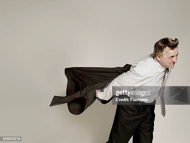 businessman struggling in the wind - taking off coat stock pictures, royalty-free photos & images