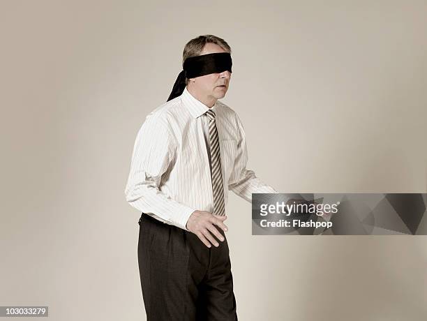 businessman wearing blindfold - blinddoek stockfoto's en -beelden