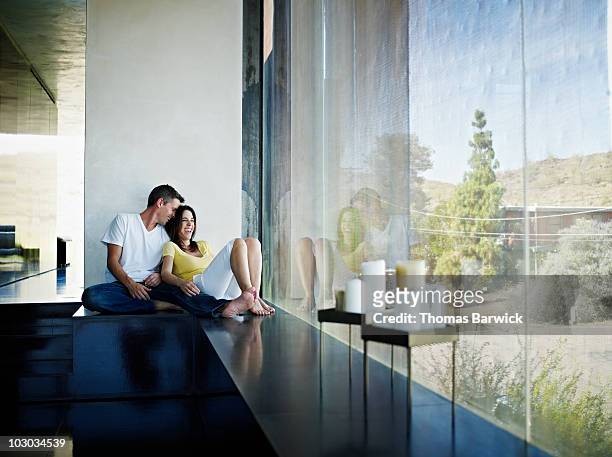 husband and wife sitting near window of home - sitta på golv bildbanksfoton och bilder