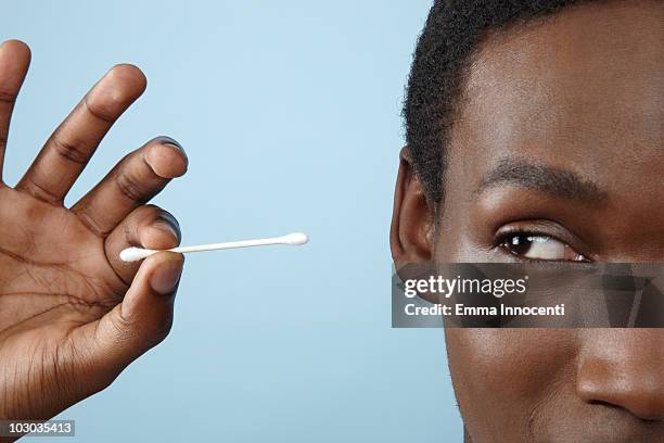 close up young man holding cotton bud - cotton swab stockfoto's en -beelden