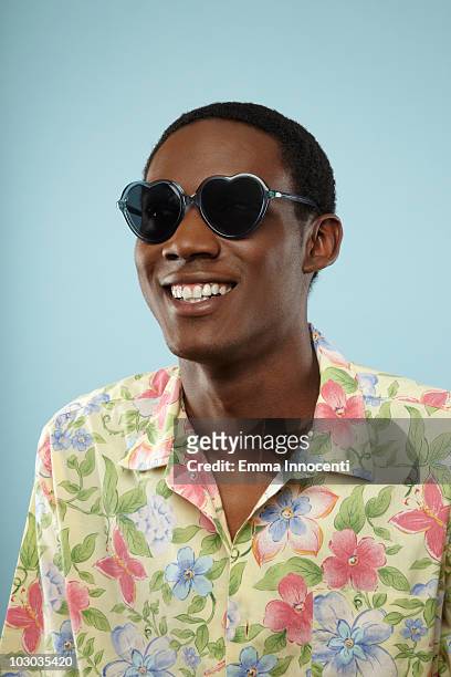 man with hearth shaped sunglasses - gebloemd shirt stockfoto's en -beelden