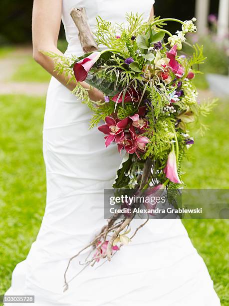 bride holding wild bouquet - bride holding bouquet stock pictures, royalty-free photos & images