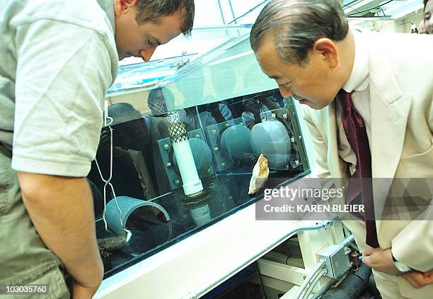 Japanese Ambassador to the United States Ichiro Fujisaki watches a zookeeper feed a Japanese Giant Salamander on July 22, 2010 during the...