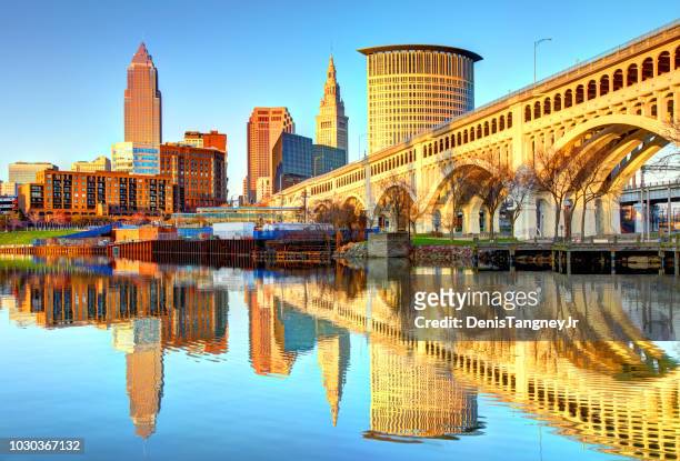cleveland skyline reflecting on the cuyahoga river - cleveland ohio stock pictures, royalty-free photos & images