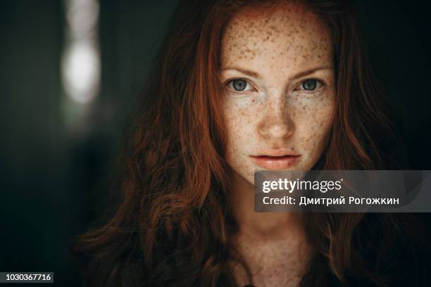 portrait of a young woman with red hair and freckles. - redhead teen fotografías e imágenes de stock
