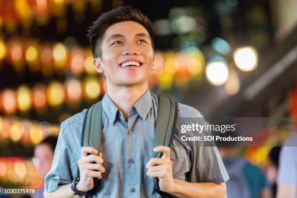 independent young man explores singapore's night life - singapore night market stock pictures, royalty-free photos & images