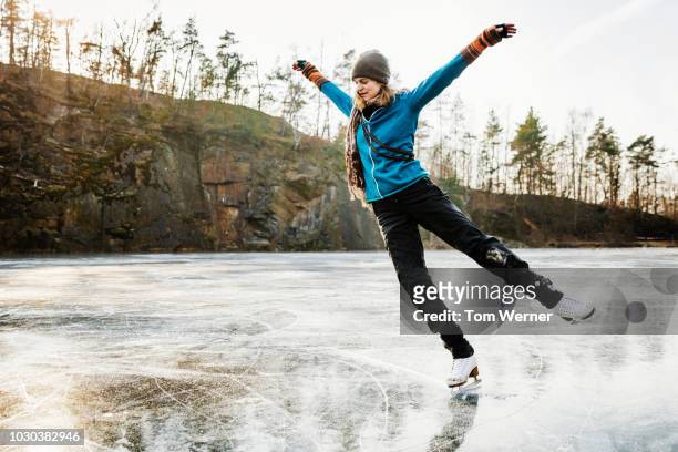 amateur ice skater posing on frozen lake - kunstschaatsen stockfoto's en -beelden