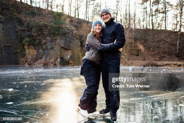 portrait of ice skating couple embracing - frozen lake stock pictures, royalty-free photos & images