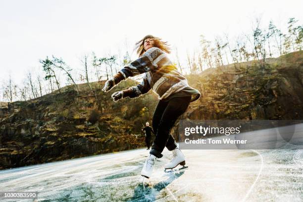 amateur figure skater mid twirl - eislaufen stock-fotos und bilder