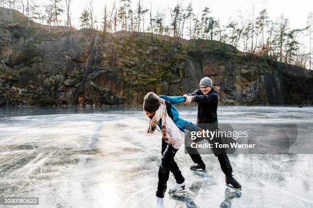 couple enjoying skating at frozen lake - figure skating couple stock pictures, royalty-free photos & images