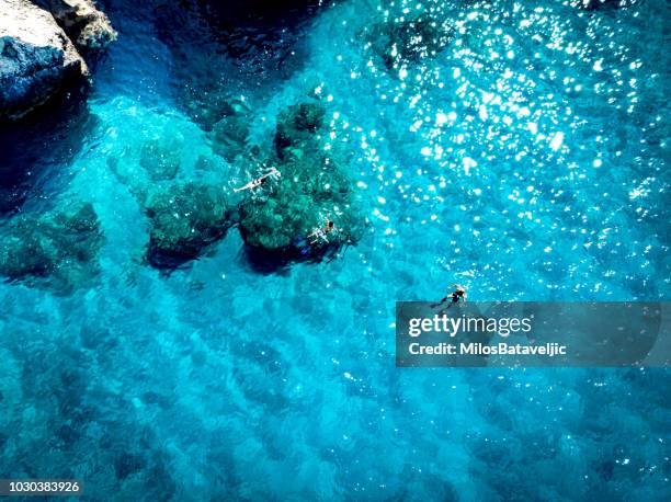 aerial view of people snorkeling in crystal clear waters - greece aerial stock pictures, royalty-free photos & images