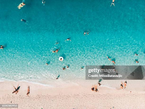 luchtfoto van mensen op het strand, ionische eilanden, griekenland - strandvakantie stockfoto's en -beelden