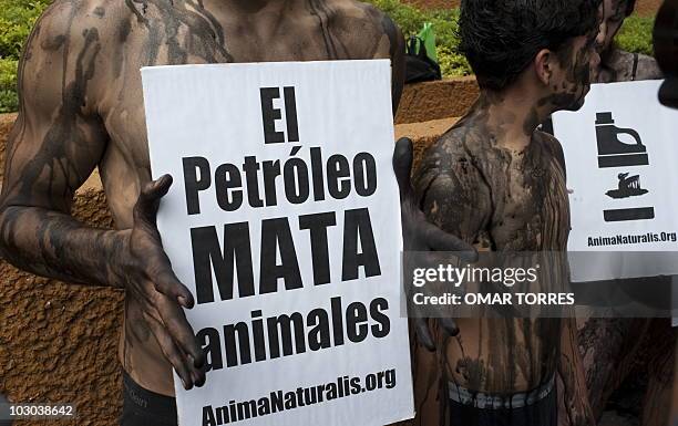 Members of AnimaNaturalis with their bodies covered with black paint protest against the oil spill of BP's drilling well in the Gulf of Mexico, on...