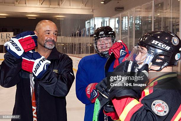 Grant Fuhr, five-time Stanley Cup Champion and Hockey Hall of Famer, left, offers some instruction to players at an on-ice clinic at the NHL And...