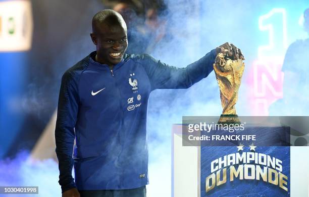 France's midfielder N'Golo Kante looks the 2018 World Cup trophy during a ceremony to celebrate the victory of the 2018 World Cup before the lap of...