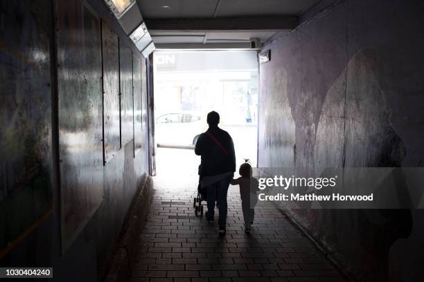Silhouetted mother and toddler walk through a subway on June 7, 2017 in Merthyr Tydfil, United Kingdom. Almost 1 in 4 people in Wales live in poverty...