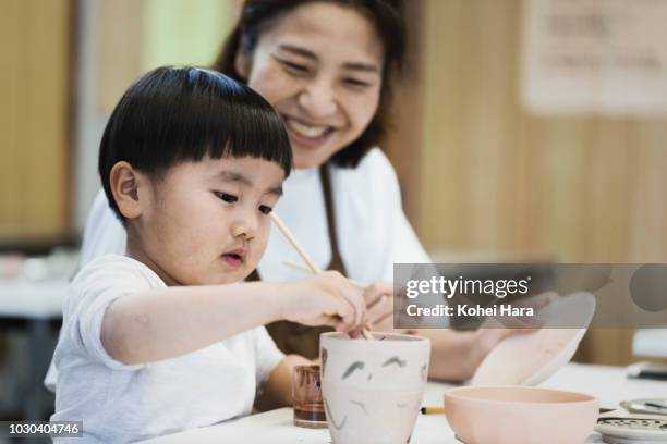 mother and son painting pottery - potter stock pictures, royalty-free photos & images