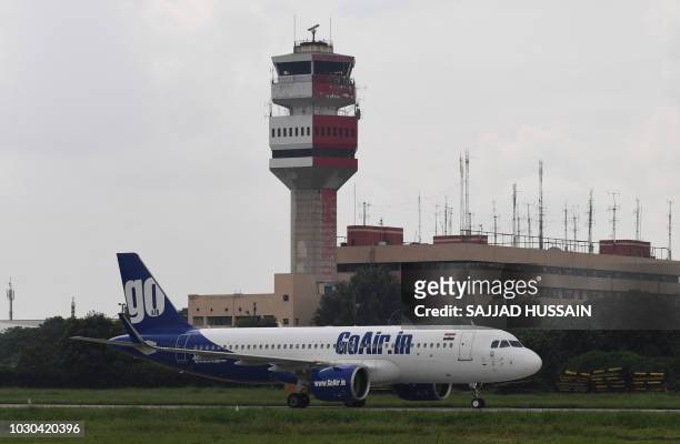 GoAir plane taxis past a control tower at Indira Gandhi International Airport in New Delhi on September 10, 2018.