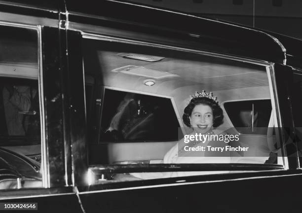 Queen Elizabeth II sitting in the backseat of a car on her way to the Confederation Centre of the Arts in Charlottetown during her visit to Canada,...