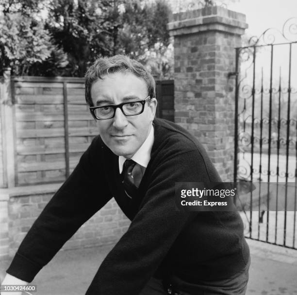 English film actor, comedian and singer Peter Sellers on a bicycle at his home in Elstead, Guildford, UK, 6th October 1964.