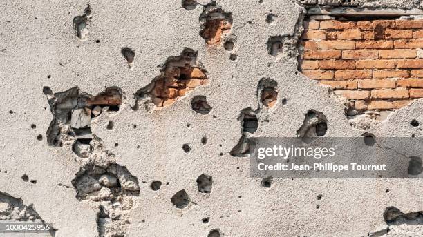 scars from a painful past - bullet holes in a wall in mostar, bosnia and herzegovina - bullet hole stock pictures, royalty-free photos & images