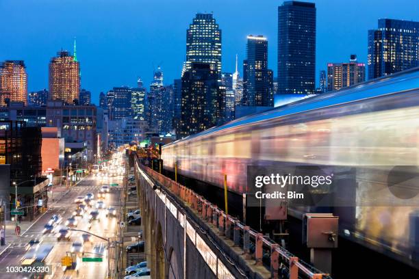 subway train approaching  elevated subway station in queens, new york - long exposure train stock pictures, royalty-free photos & images